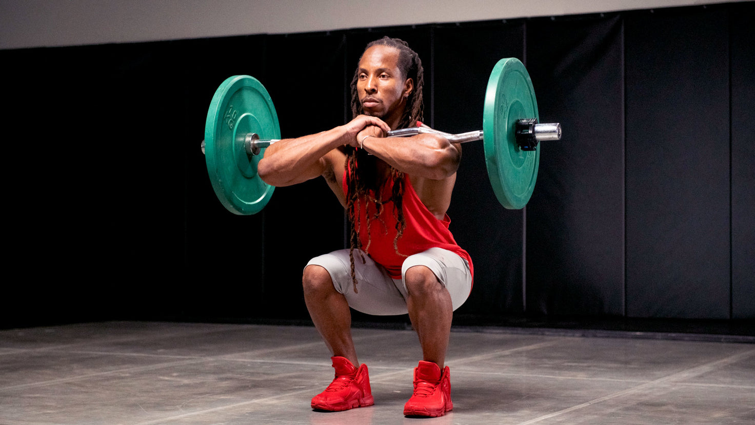 Torre Washington performing a front squat with a loaded barbell.