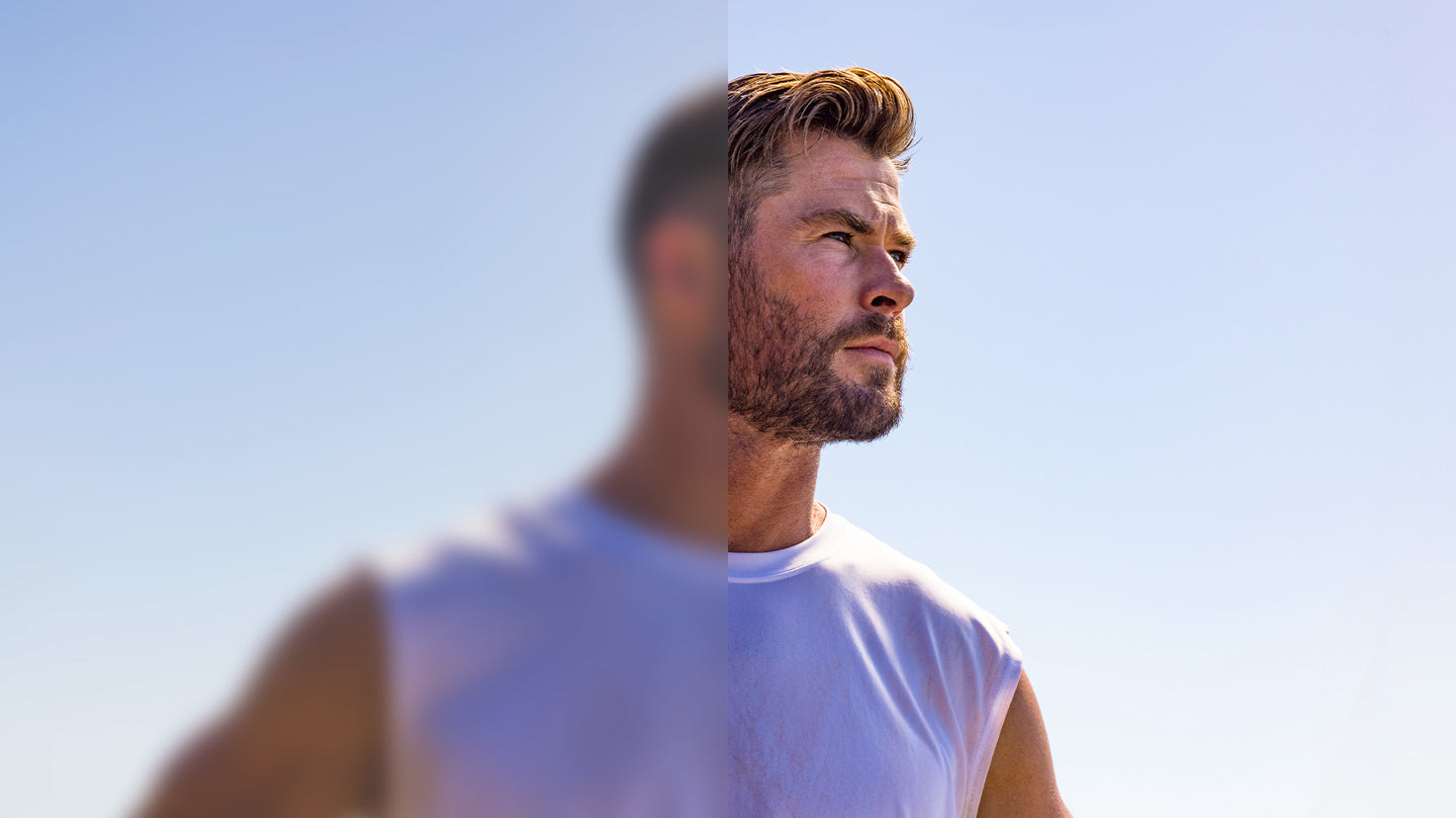 An image of Chris Hemsworth wearing a white tank top, looking out into the distance.