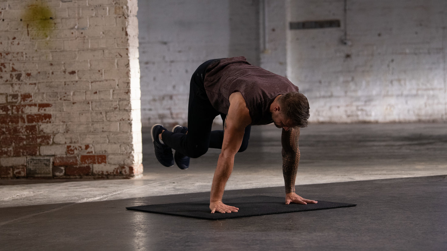 Centr trainer Bobby Holland Hanton performs a bodyweight shoulder exercise.