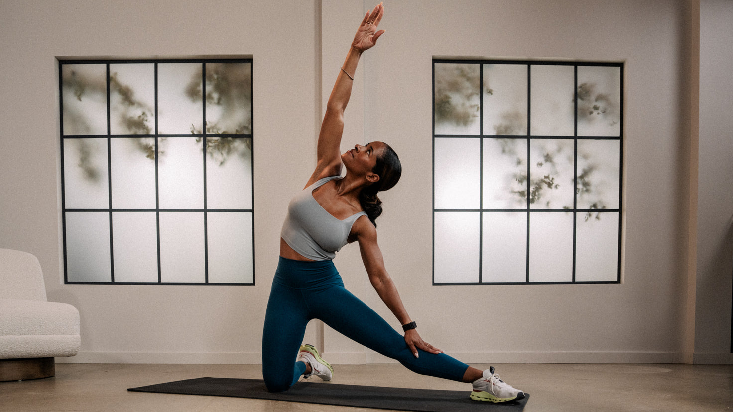 Ingrid Clay performs a kneeling side lunge to the left, and side stretch with right arm raised.