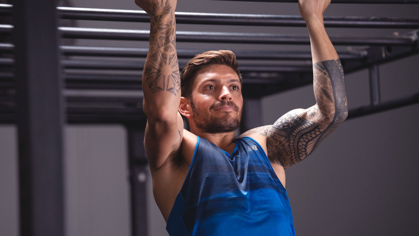 Luke Zocchi performing a pull up on a metal bar.