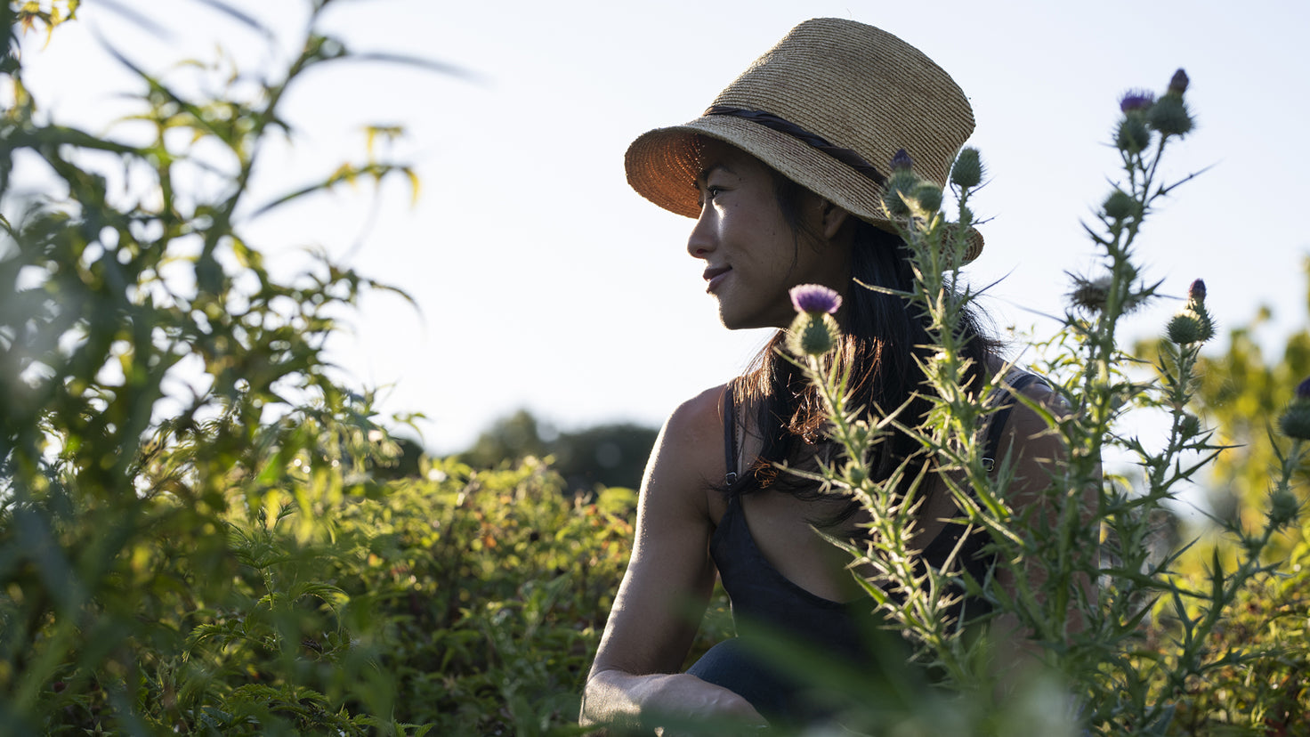 Palisa Anderson sits in her garden surrounded by edible plants.