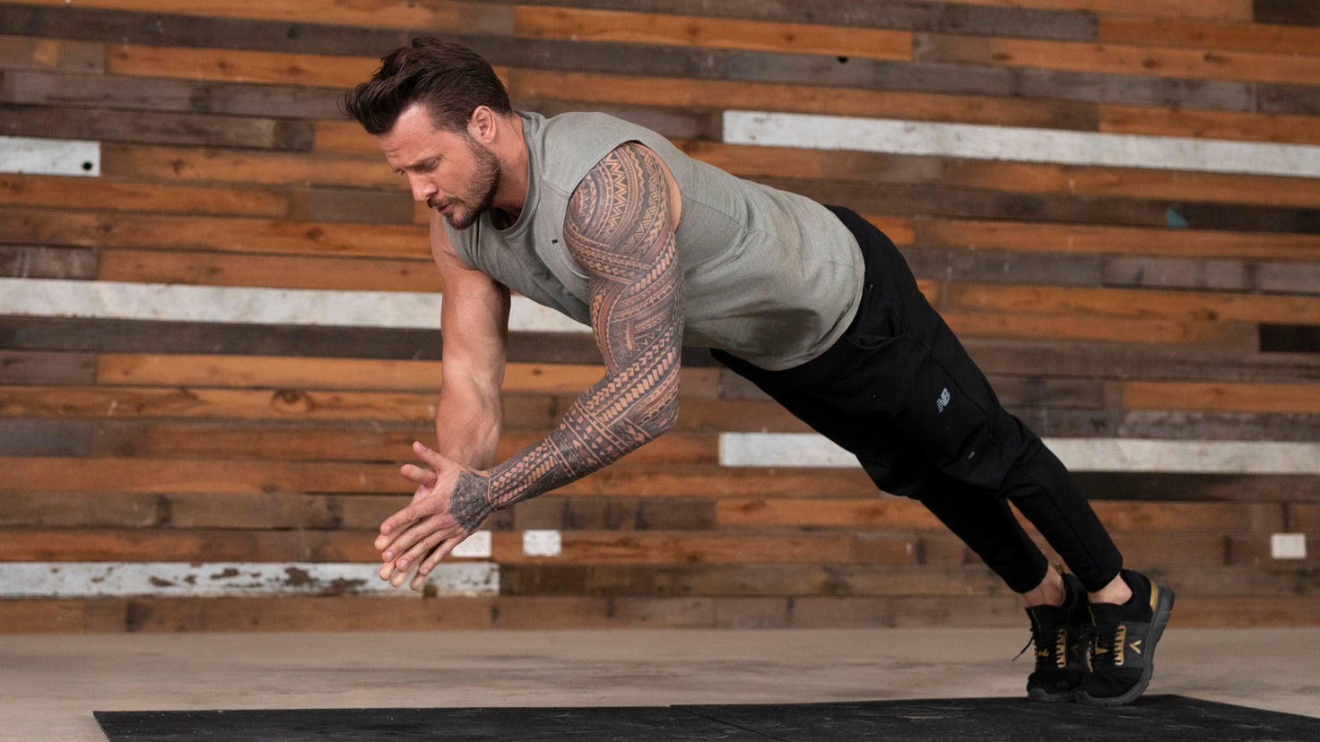 Centr trainer Bobby Holland Hanton performs a push-up with hand clap, in a workout studio.