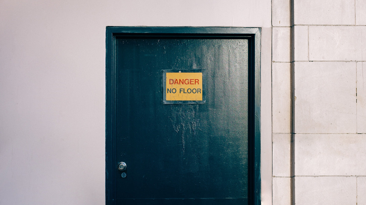 Door with a sign that says 'Danger No Floor' taped to it.