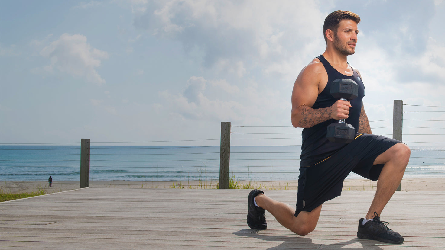 Luke Zocchi performing a lunge exercise with dumbbells.