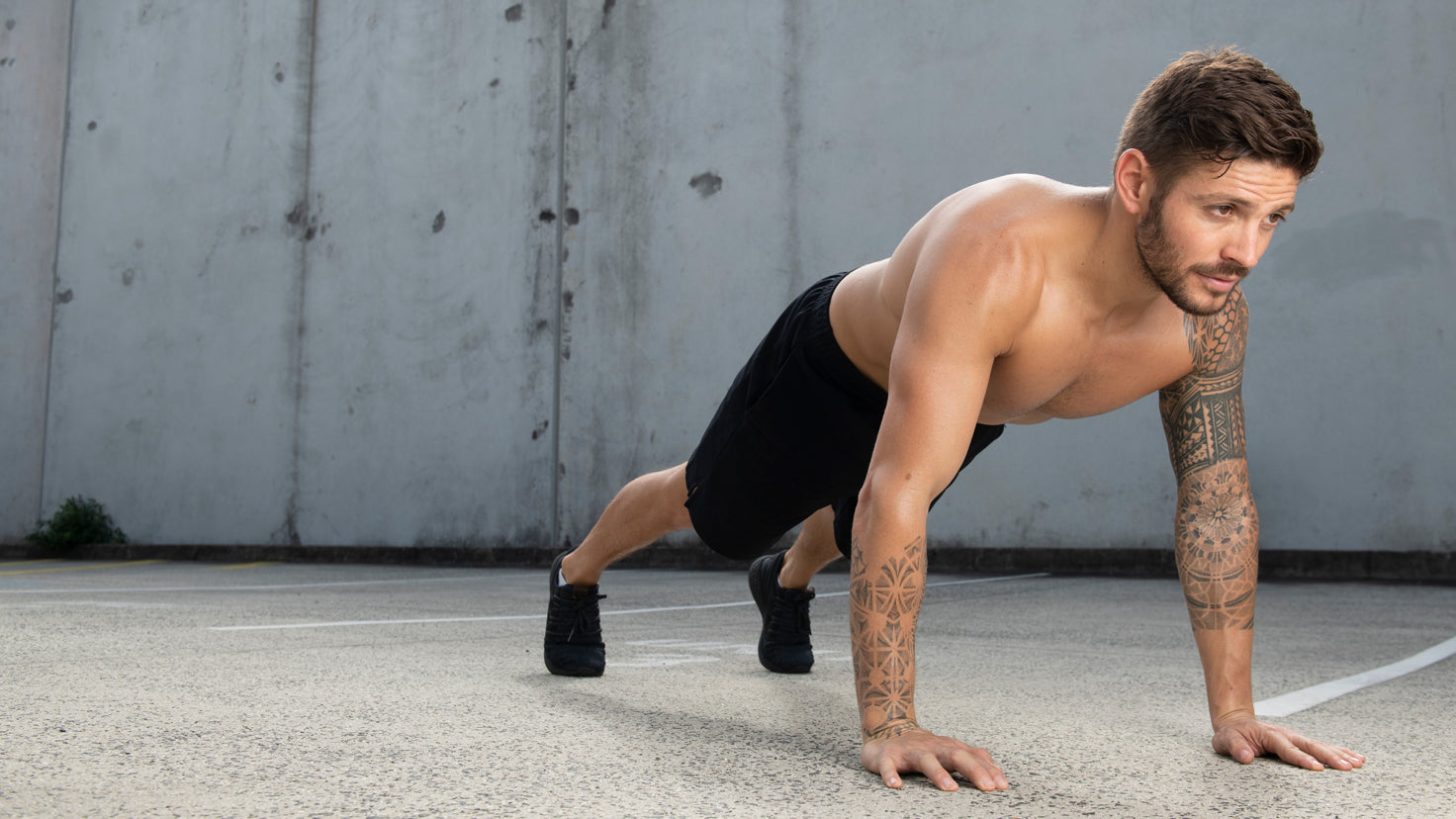 Luke Zocchi performs a push-up shirtless.