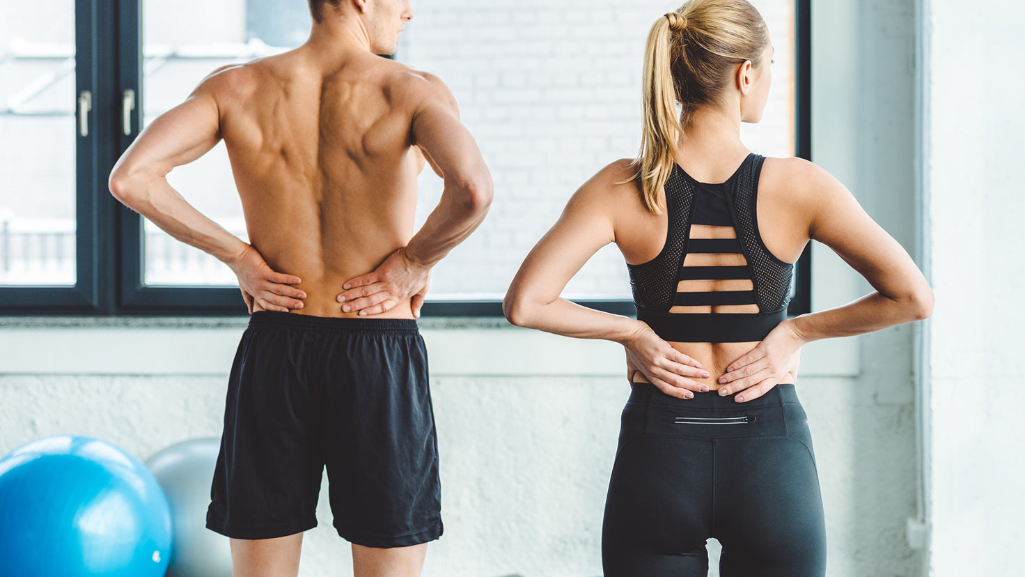 Two people hold their sore backs.