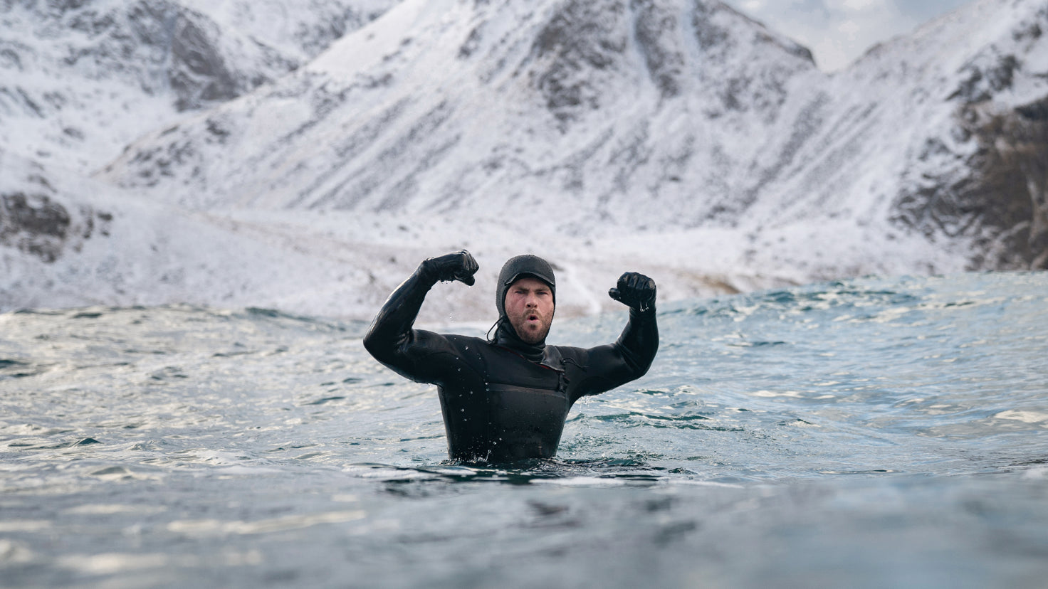 Centr founder Chris Hemsworth, wearing a wetsuit and immersed in cold water, flexes his biceps.