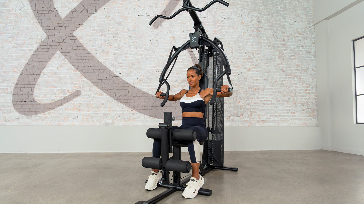 Centr trainer Ingrid Clay works out using Centr's Multi Gym Strength machine.