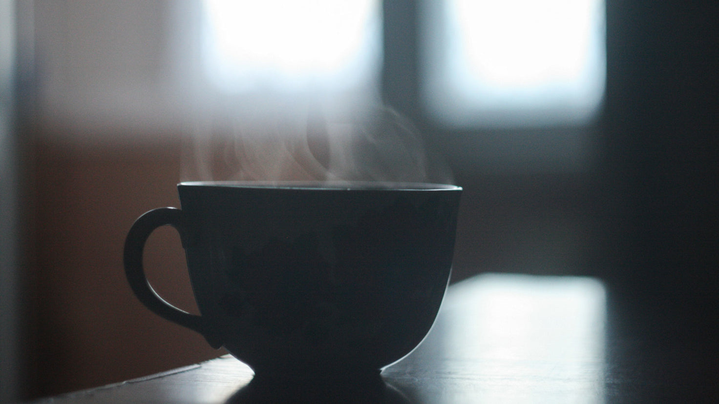 Close up of a steaming hot drink in a tea cup.