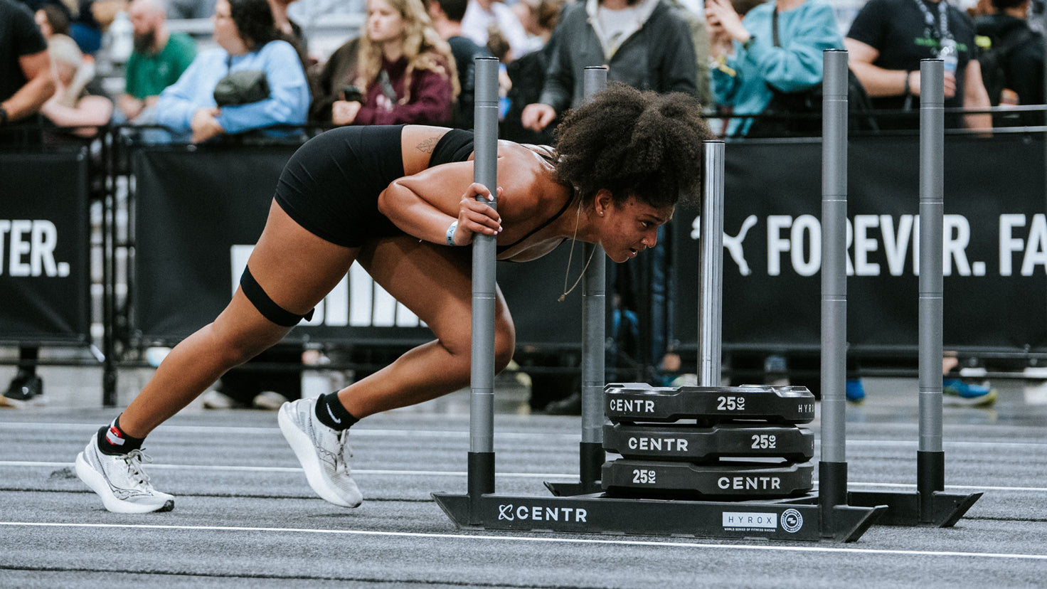 An elite Hyrox athlete pushes a sled in a Hyrox race.
