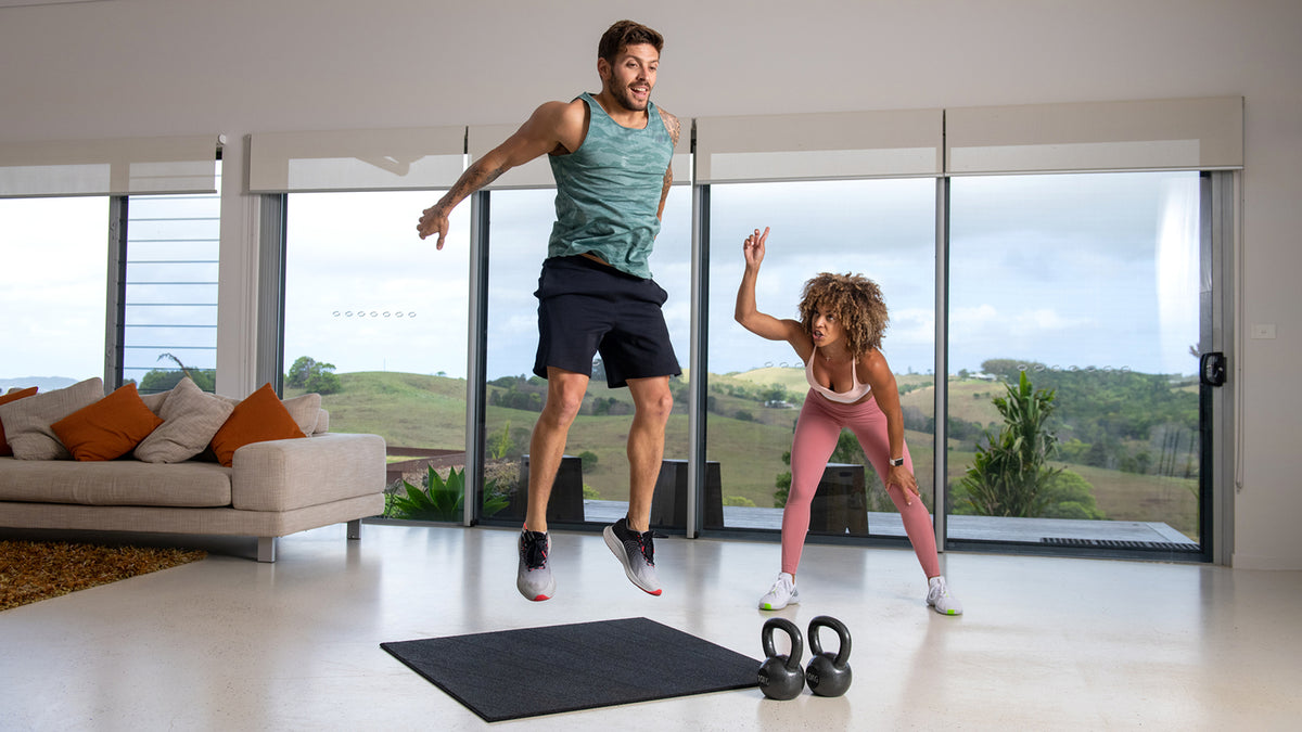 Ashley Joi shouts encourgement at Luke Zocchi while he does jump squats.