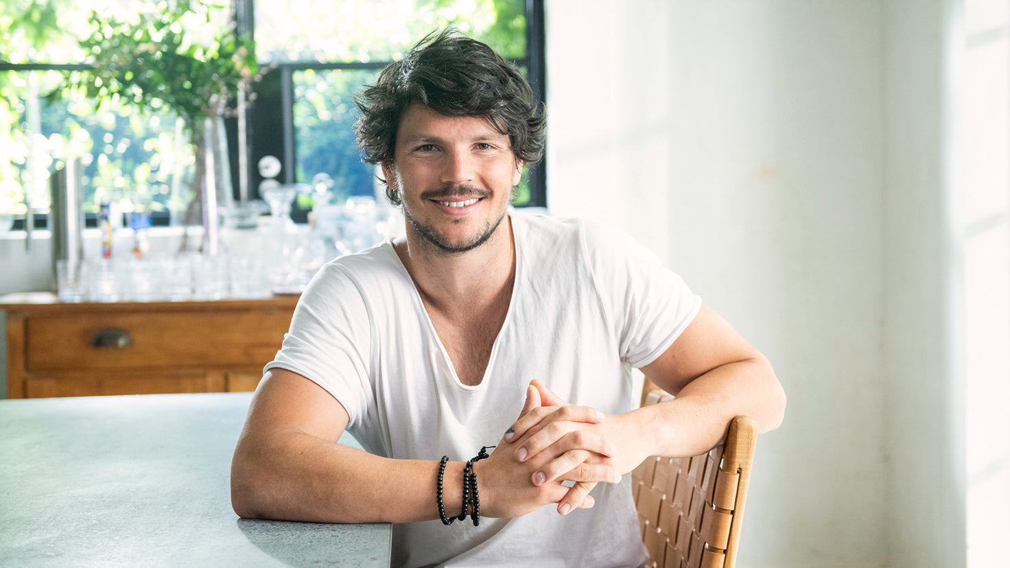Dan Churchill sits smiling in a kitchen.