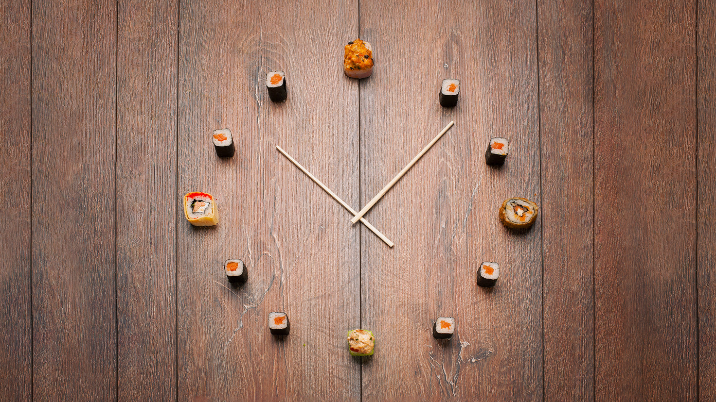 A clock where the numbers are represented by pieces of sushi.