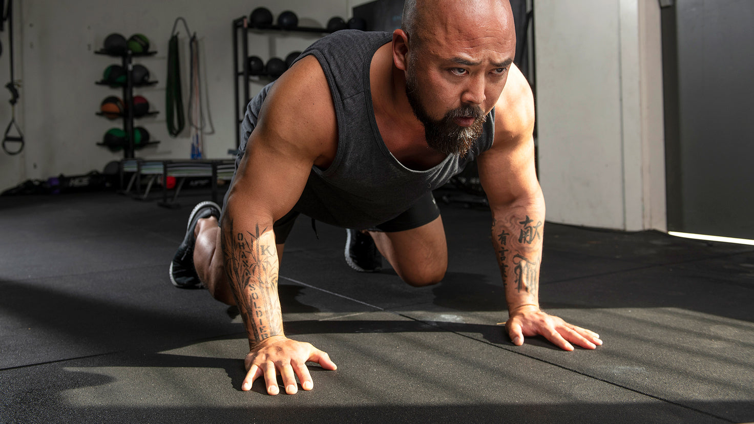 Joseph 'Da Rulk' Sakoda doing a bear crawl exercise in a gym.
