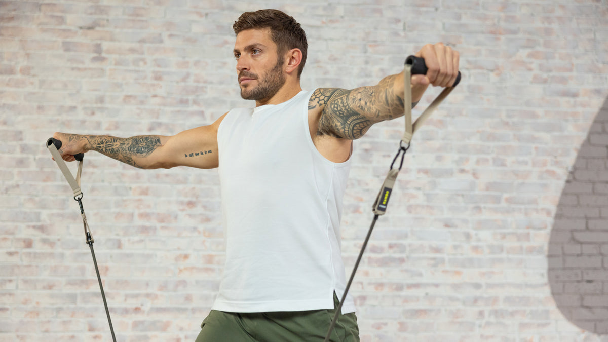 Luke Zocchi performs lateral arm raise using his Centr resistance bands.