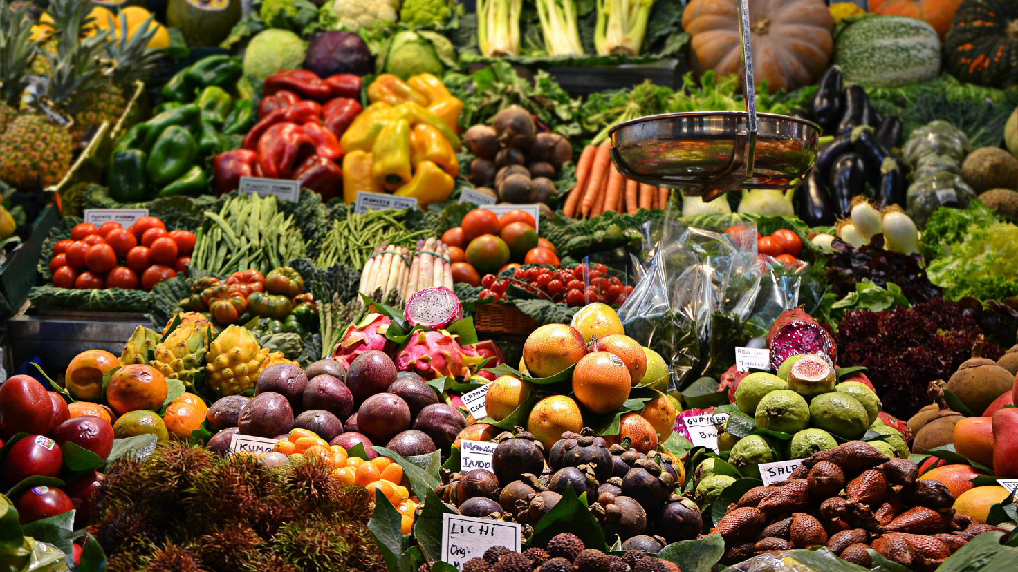 A display of colorful fruits and vegetables at a market stall.