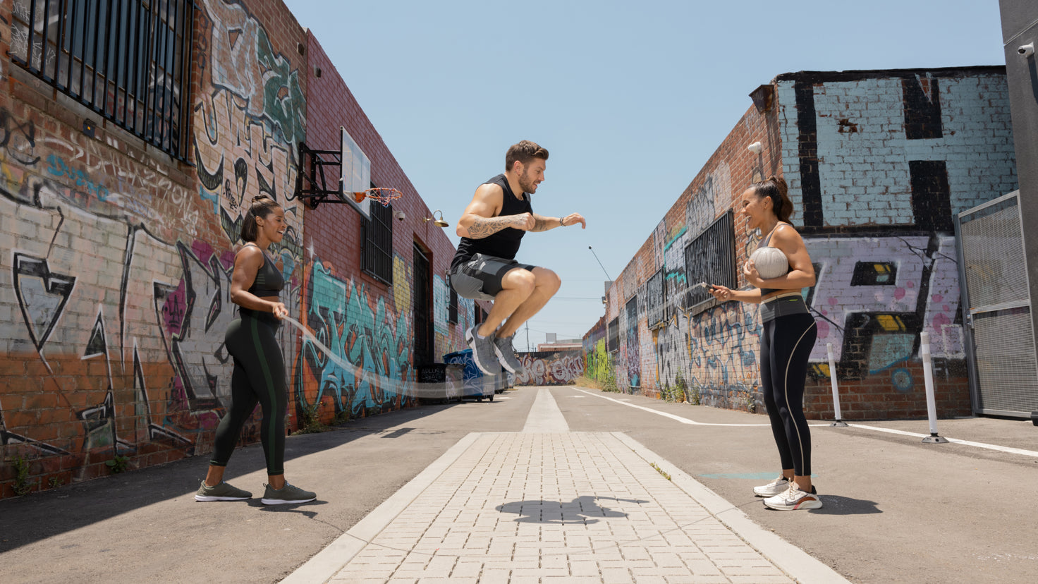 Centr trainers Ingrid Clay, Maricris Lapaix twirl a skipping rope for Luke Zocchi to jump.