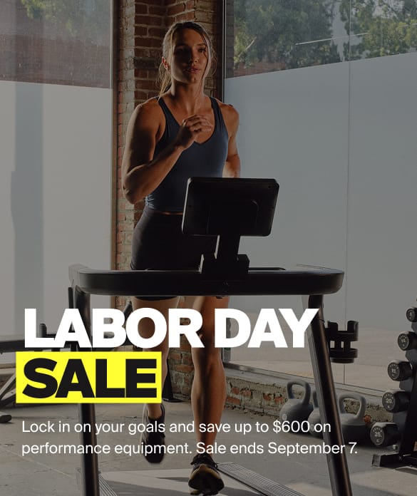A woman running on a treadmill in a gym setting with large windows and brick columns, overlaid with promotional text reading 'LABOR DAY SALE' and additional sale copy.